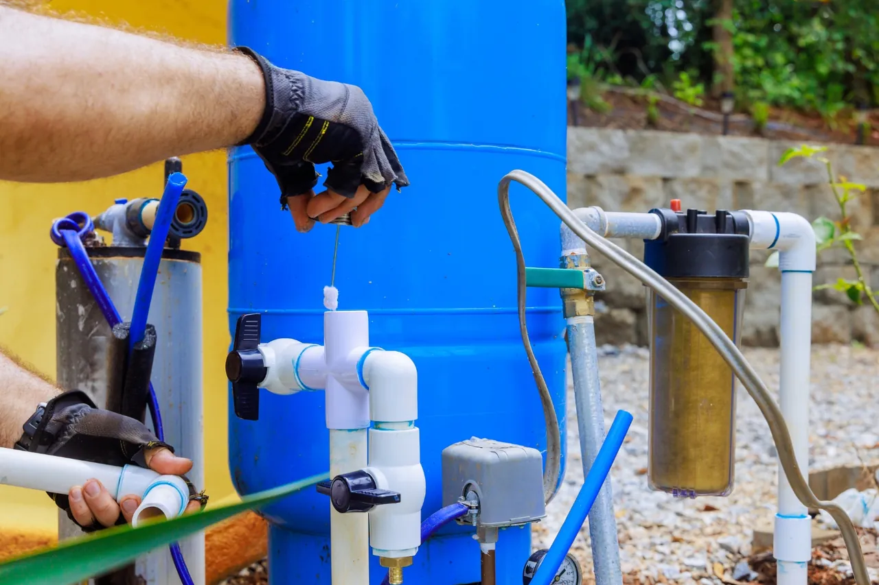 Técnico fixando filtro de sedimentos em linha na tubulação do tanque azul, sistema de filtragem para poço artesiano no Rio de Janeiro